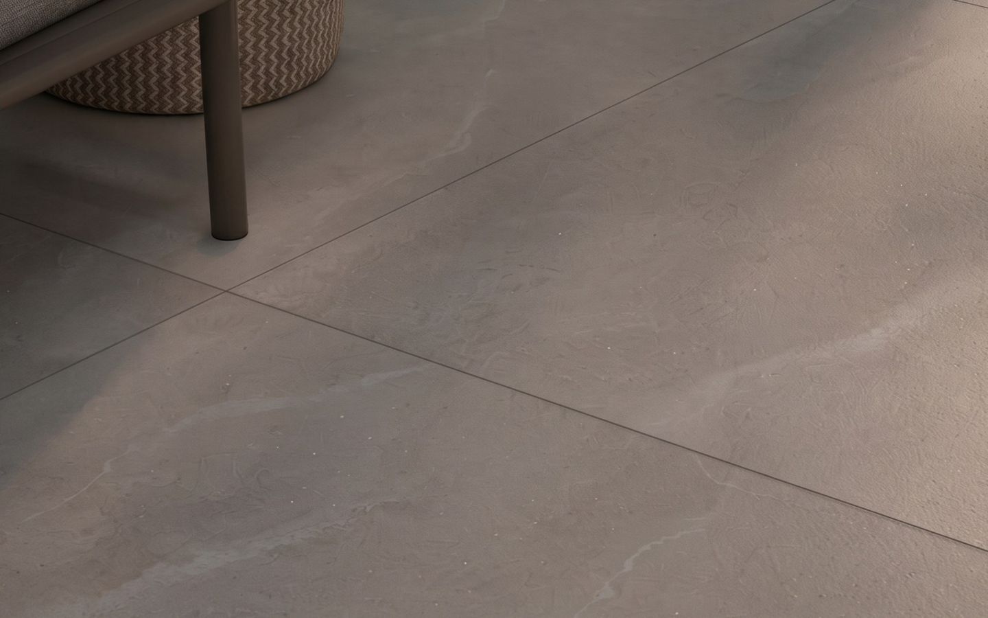 Sala com piso de porcelanato cinza de grande formato e uma poltrona