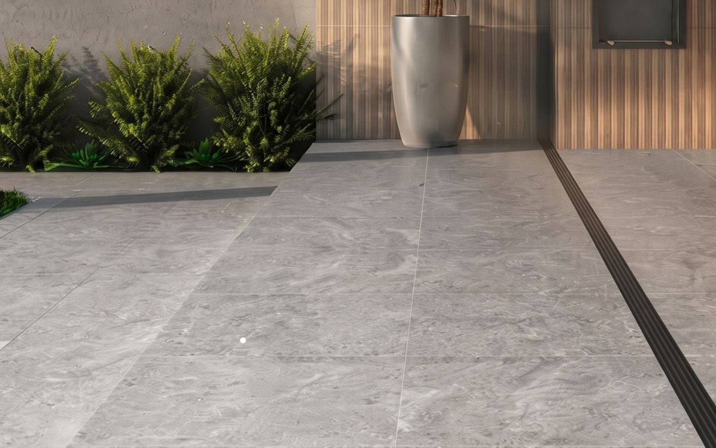 Área externa com piso de porcelanato cinza, plantas e um vaso grande